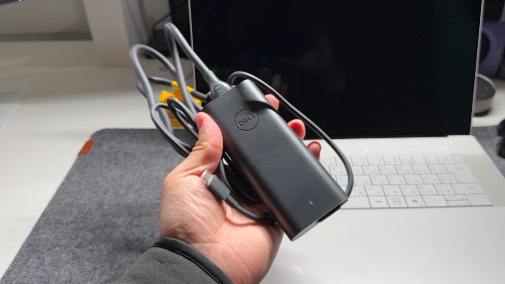 Dell 16 Premium付属の130W Type-Cアダプターを手で持った写真。従来のゲーミングノート用アダプターと比べて非常にコンパクト