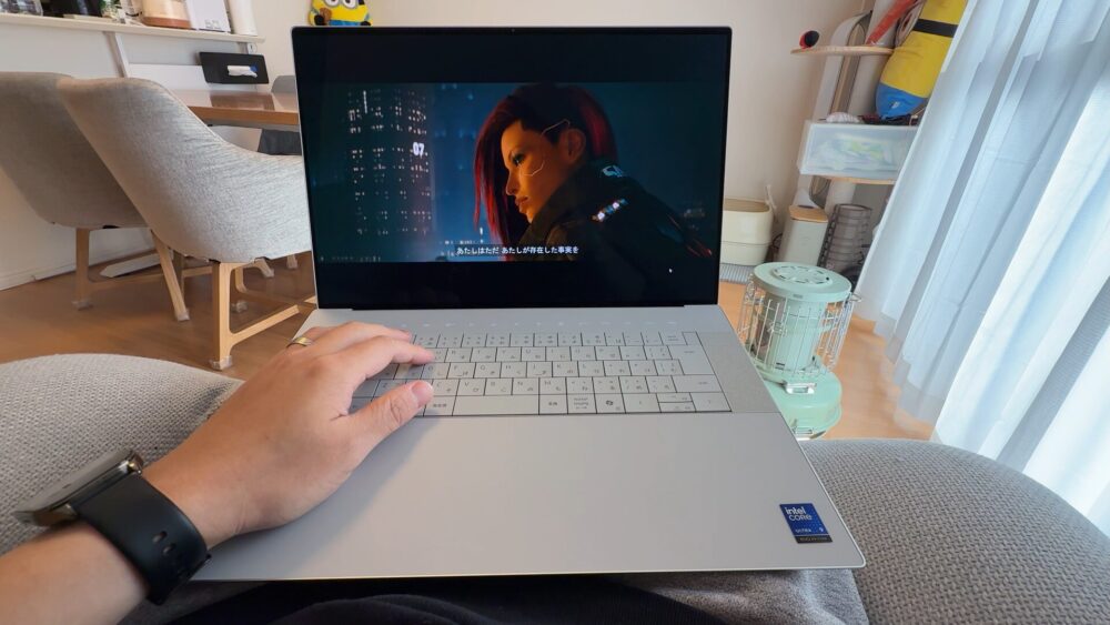 ソファでDell 16 PremiumでCyberpunk2077をプレイしている様子。4K OLEDディスプレイの美しさが分かる
